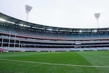 A view of an empty stadium, looking a cross the ground with goalposts on the far left.