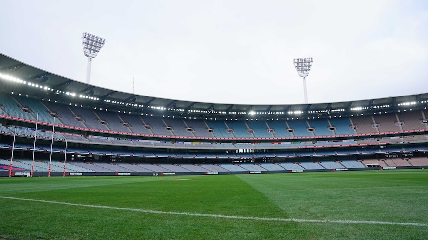 A view of an empty stadium, looking a cross the ground with goalposts on the far left.