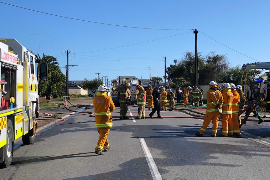 CFS firefighters outside a damaged home.