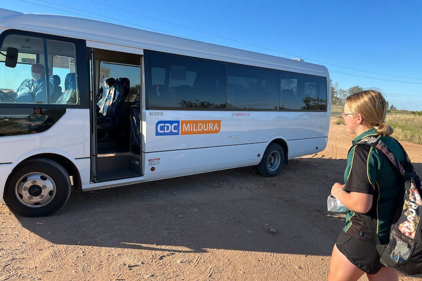 Georgia Strachan is dressed in her Coomealla High School uniform. She has her backpack on and is about to walk onto a mini bus