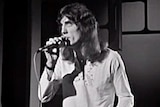 Black and white TV still of Jon English sing during a TV performance in 1972.