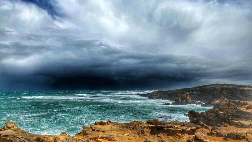 Ominous dark storm clouds over a churning ocean