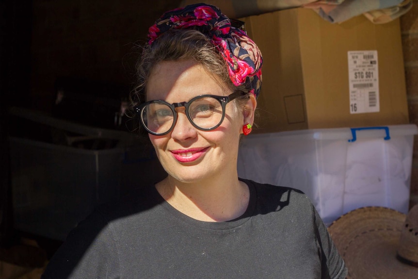 Ilona Harker smiles in front of the storage unit where she keeps her belongings