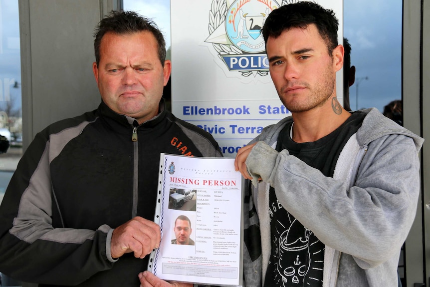 Mark and Tamati hold a missing person poster between them.