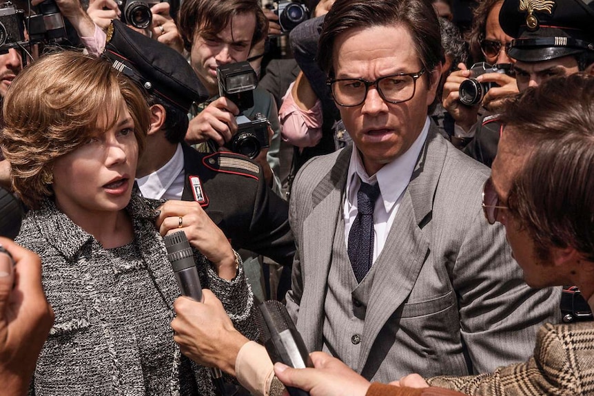 Actor Michelle Williams and Mark Wahlberg surrounded by press and photographers in a scene from the film.