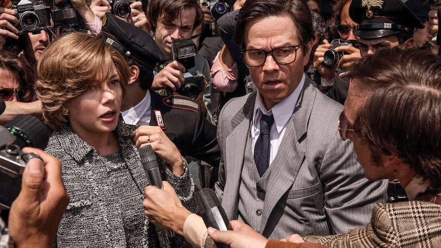 Actor Michelle Williams and Mark Wahlberg surrounded by press and photographers in a scene from the film.