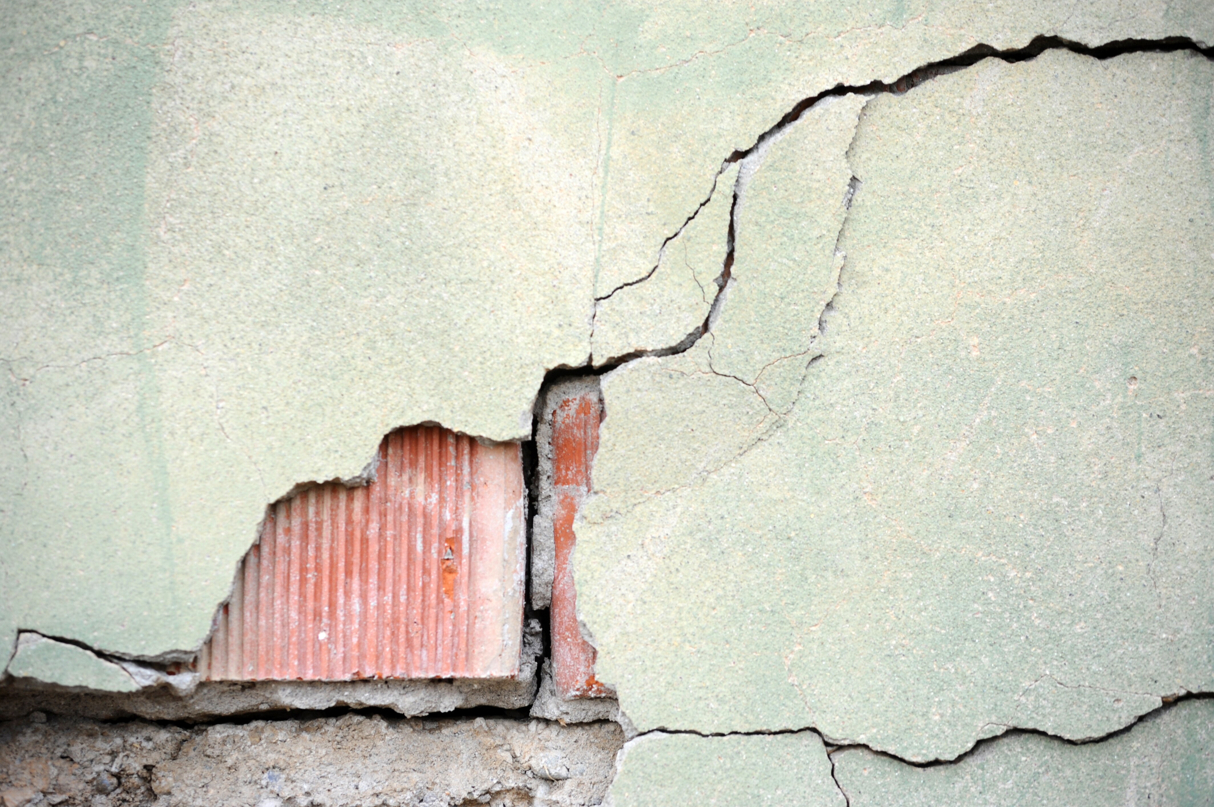 Cracked exterior of a building, with the text "earthquake"