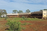 A triple road-train loaded with cattle leaving yards