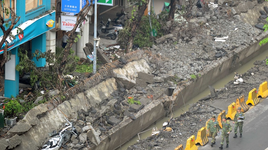 Soldiers walk past the gas explosion site in Kaohsiung City on August 2, 2014