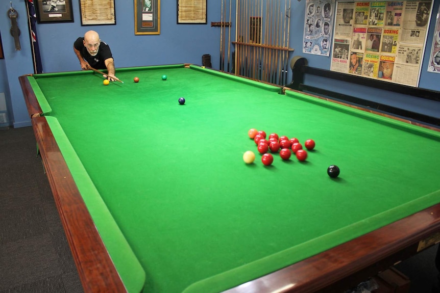 A man gets ready to take a shot at a billiard table