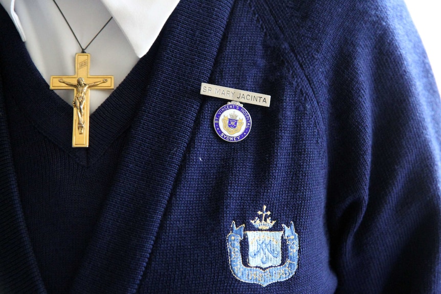 Sister Jacinta Fong wears a gold cross embellished with Jesus, and her nametag for the St Vincent's Hospital.