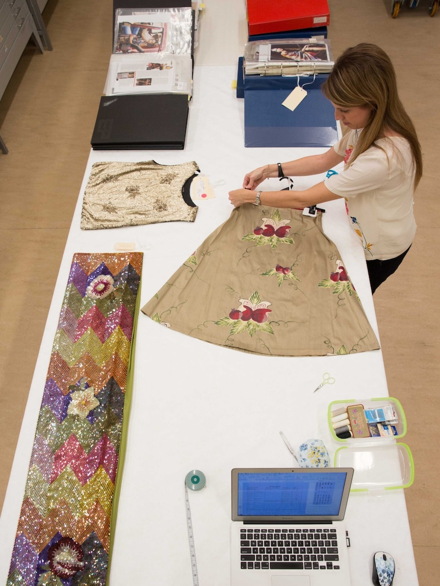 Louise McCullagh spreads a dress on a table.