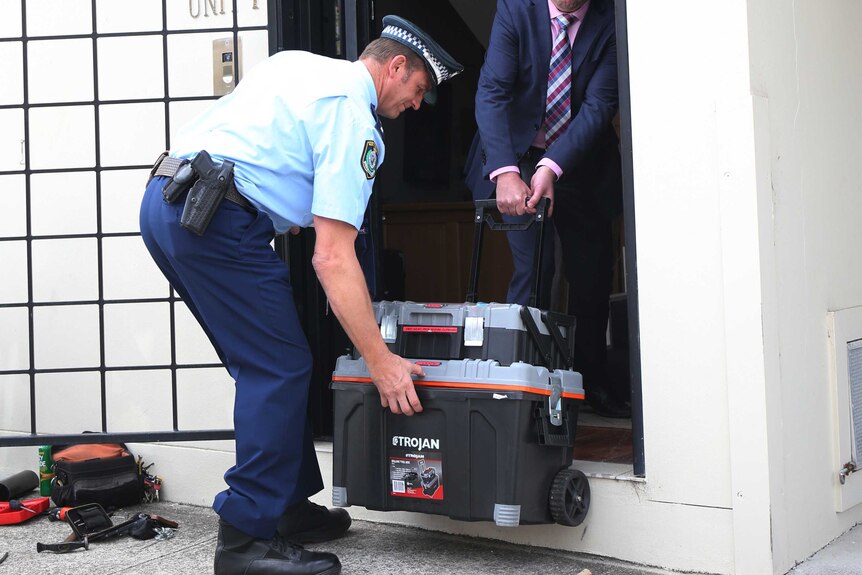 Police officers enter the office of sports agent Sam Ayoub in Leichhardt in Sydney.