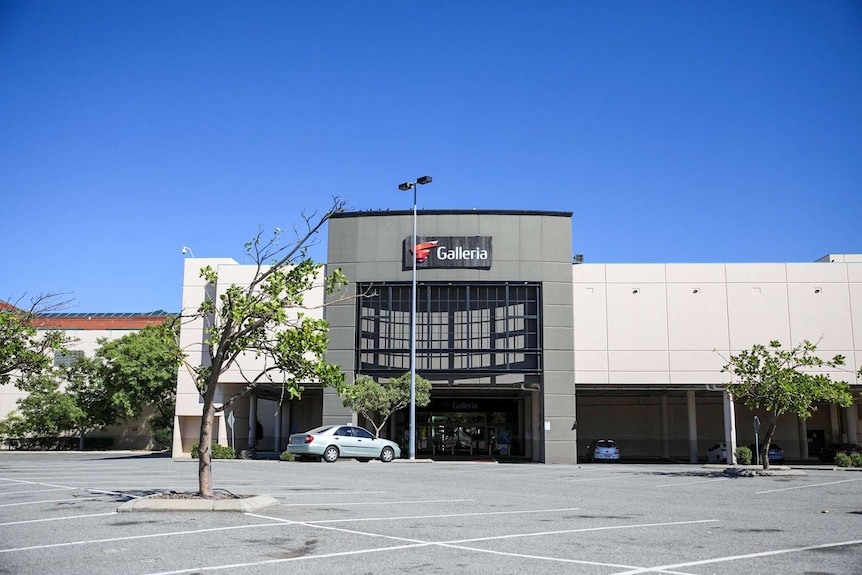 Just two cars parked in the carpark of a suburban shopping centre on the first day of the lockdown affecting Perth