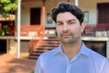 A portrait of Daniel Bavcevic looking serious and standing in front of the Legal Aid building in Broome 