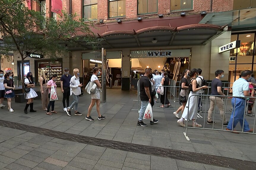 Shoppers queueing to enter a shop