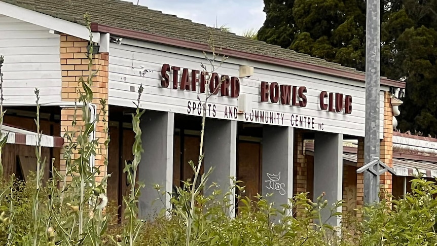 A disused bowling club that is overgrown with weeds.