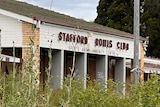 A disused bowling club that is overgrown with weeds.
