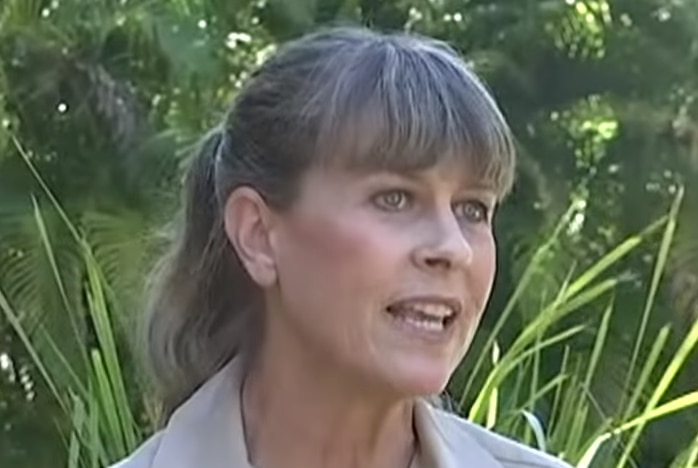 Robert and Terri Irwin stand near some tropical greenery.