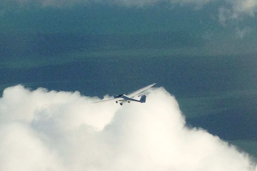A white glider dwarfed by a huge morning glory cloud in the Gulf of Carpentaria, above Burketown.