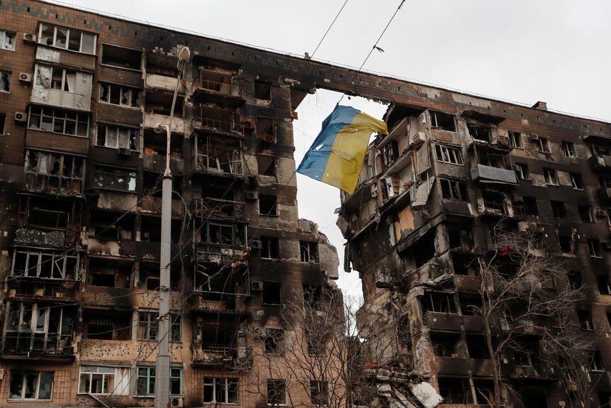 A view shows a torn flag of Ukraine hung on a wire in front an apartment building.