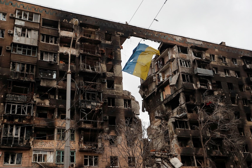 A view shows a torn flag of Ukraine hung on a wire in front an apartment building.