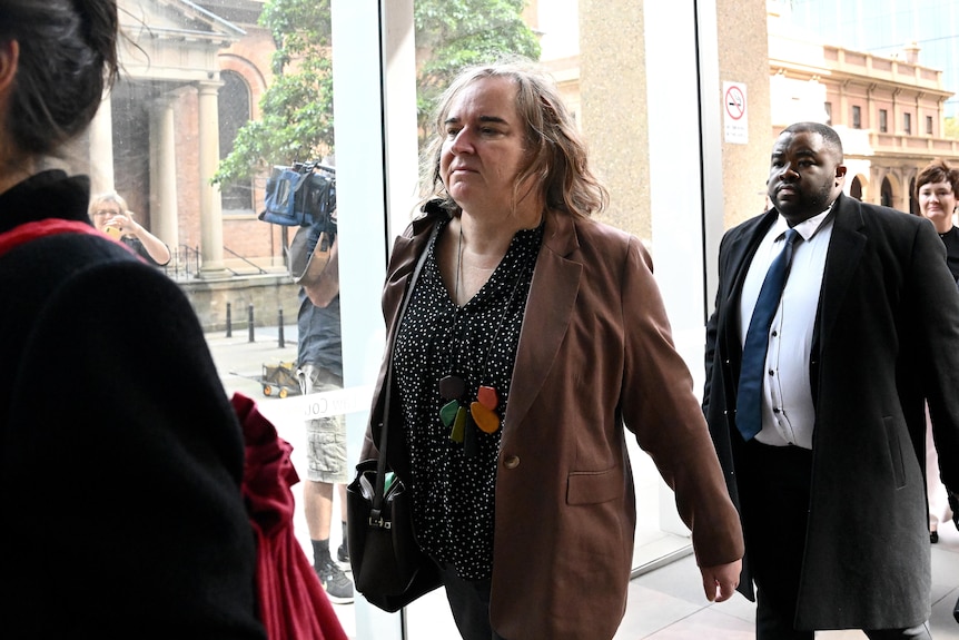 A transgender woman walks inside a court building.