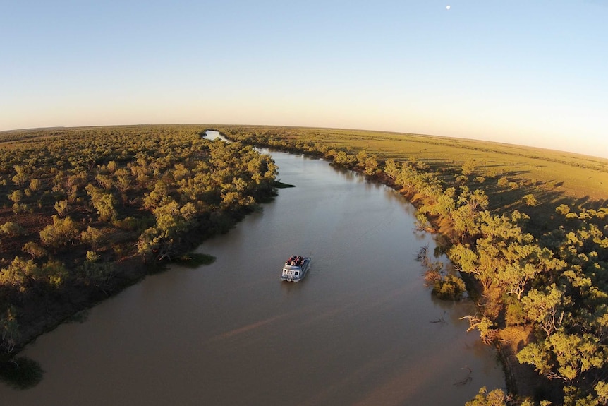 An aerial shot of a cruise boat on a river in outback Queensland.