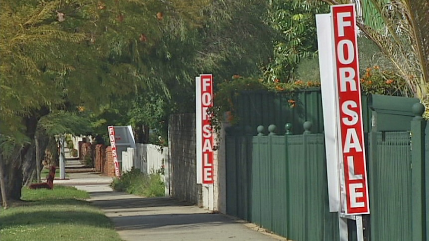 For sale signs line a street