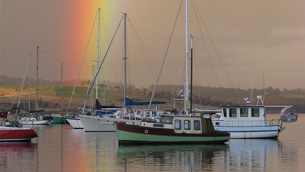Rainbow over boats moored at marina