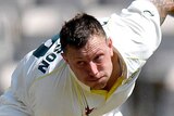 James Pattinson bends his back as he follows the ball with his eye while bowling