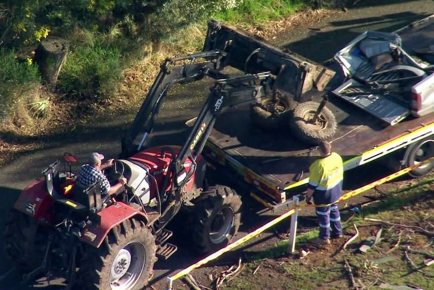A tractor loads debris onto a truck