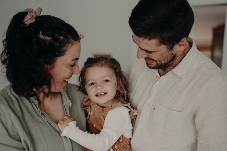 Emilee Cherry and her partner hold their daughter.