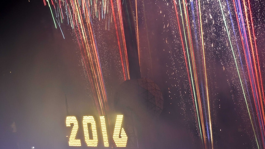 Fireworks explode past the Times Square Ball after it is dropped to signal the start of 2016.