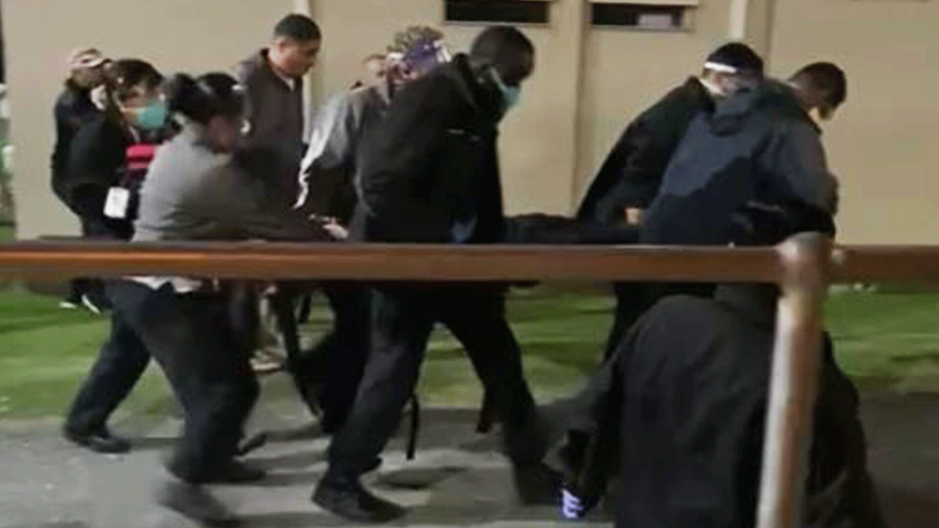 A man is being carried away on a stretcher at Yongah Hill detention centre