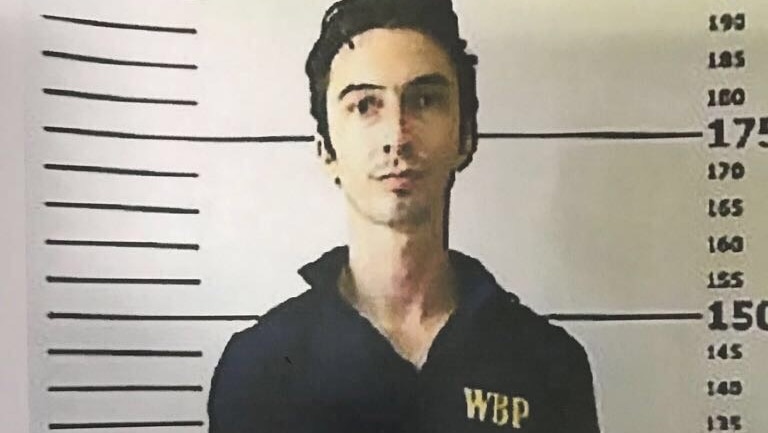 Mugshot of Christian Beasley, who escaped from Bali's Kerobokan prison. He is tall with dark hair and fair skin.