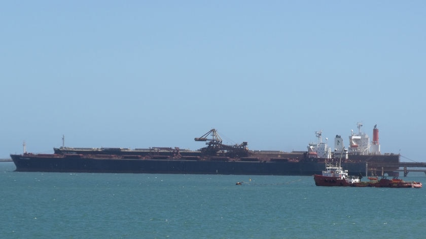 Iron ore carrier at the port in Dampier with tug in foreground