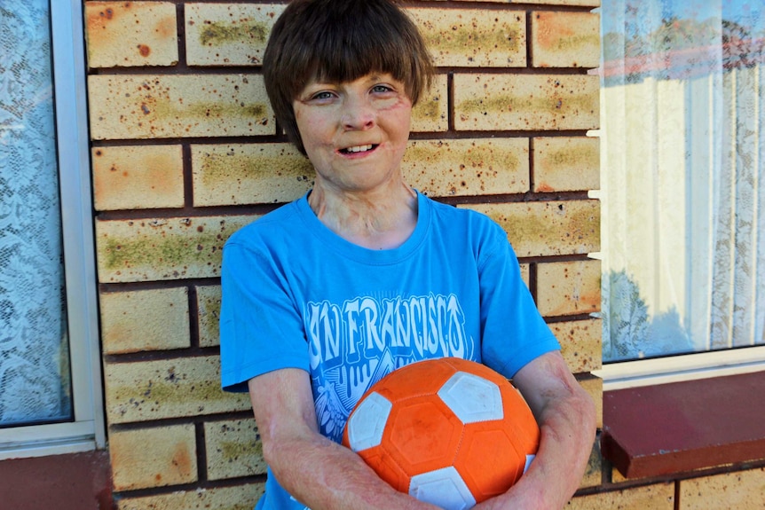 Spencer Connelly holds a soccer ball.