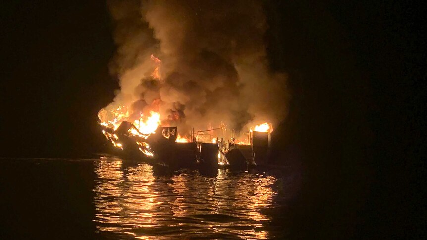 Photo shows dive boat is engulfed in flames surrounded by dark sea and sky.