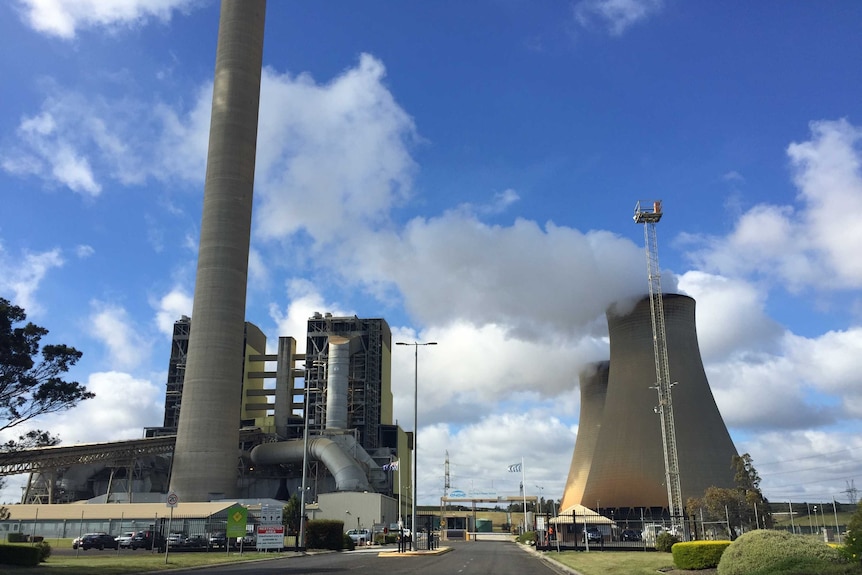 A  large power station with chimneys set against a blue sky