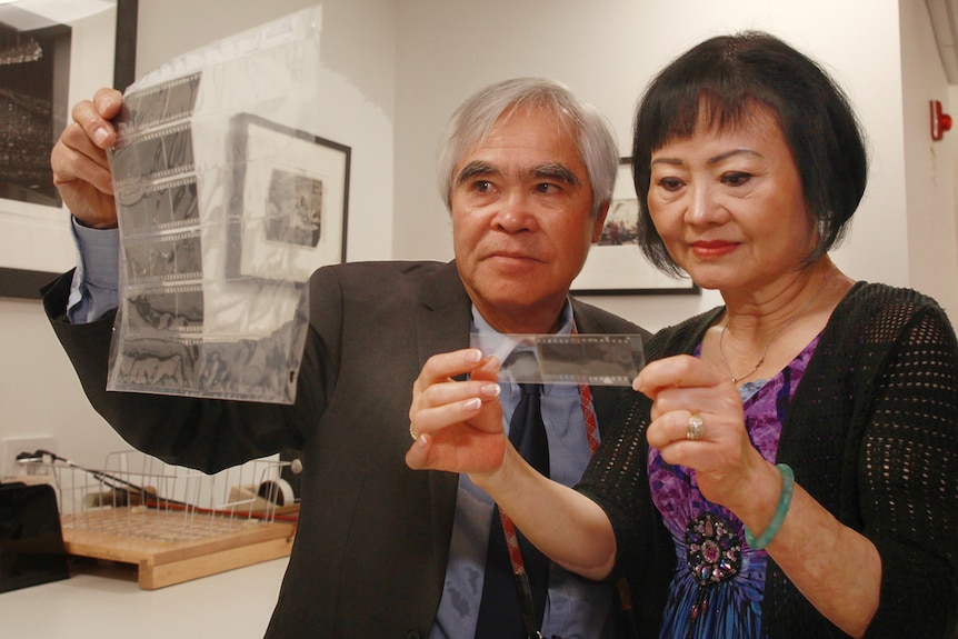 Kim Phuc and Nick Ut look at the original negatives of the iconic 'Napalm Girl' photo at the AP headquarters photo library