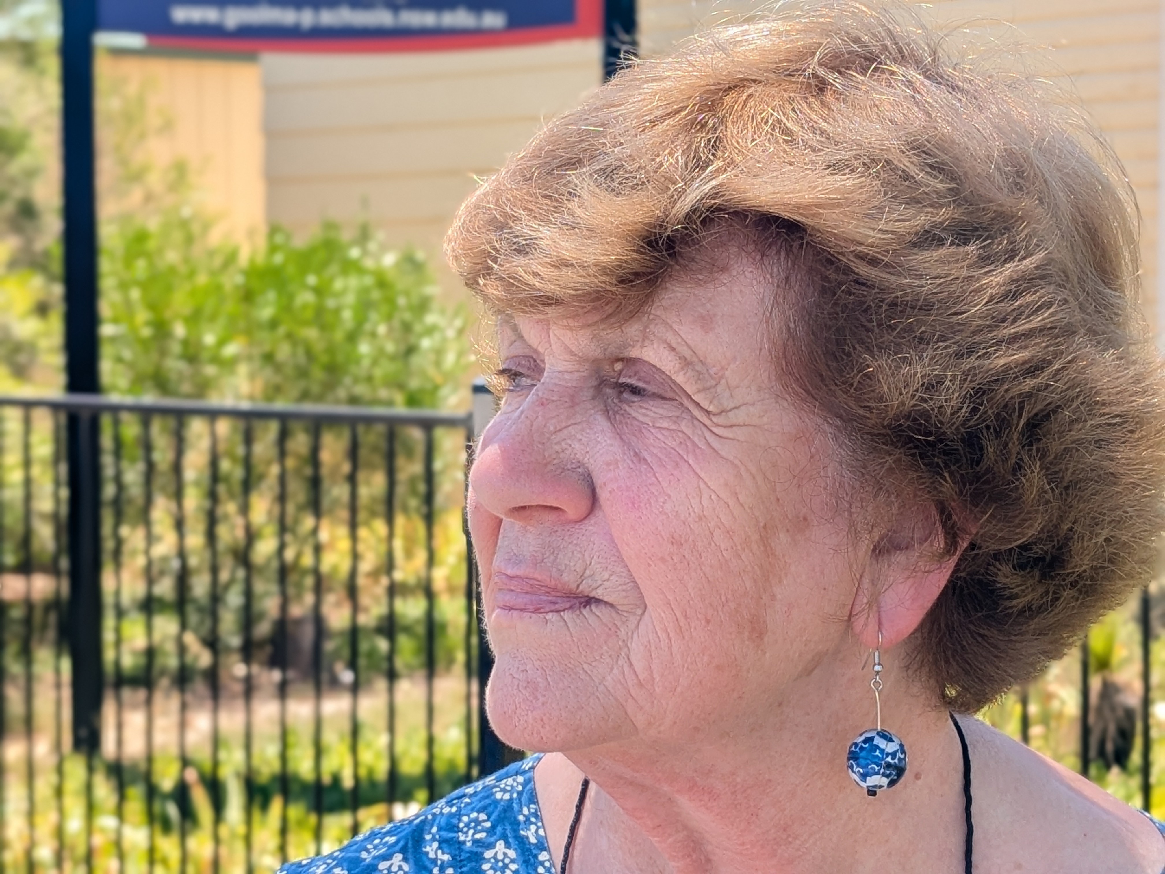 Una mujer mayor mira perdidamente a lo lejos.