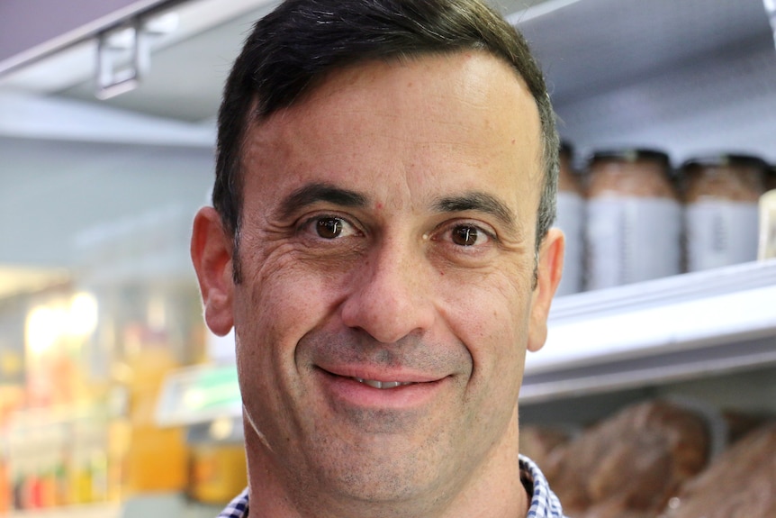 A close up shot of a middle aged man inside a grocery store