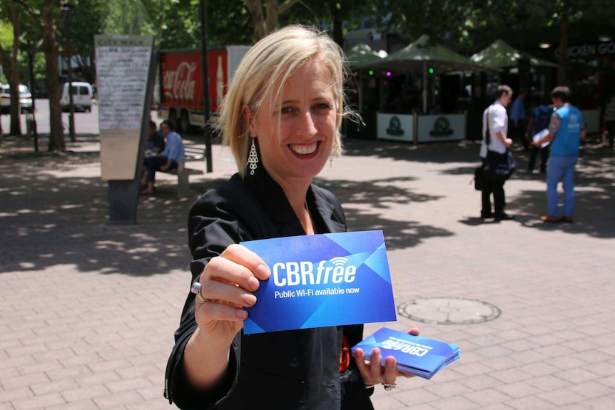 A woman smiles at the camera holding a card that reads 'CBRfree'.