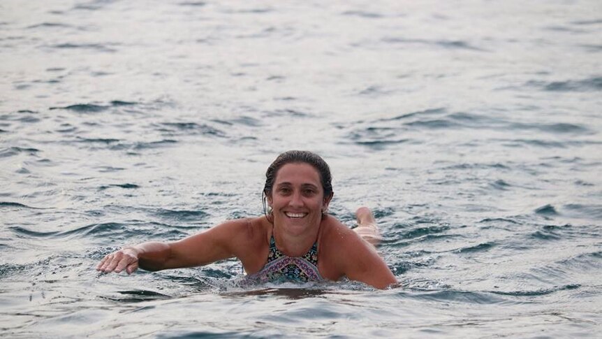 Woman paddling in the ocean.