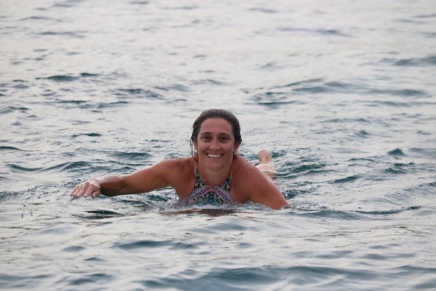 Woman paddling in the ocean.