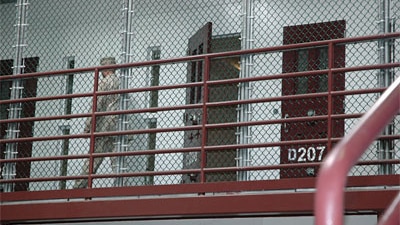 Guard  walks past an unoccupied cell at in Guantanamo Bay's high security section