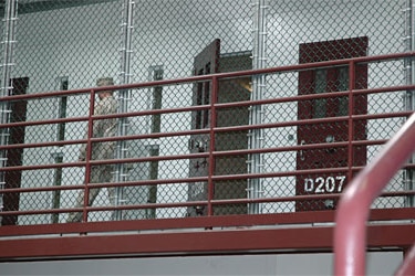 Guard  walks past an unoccupied cell at in Guantanamo Bay's high security section