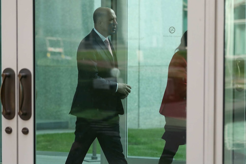 A side-on shot of Peter Dutton walking through Parliament