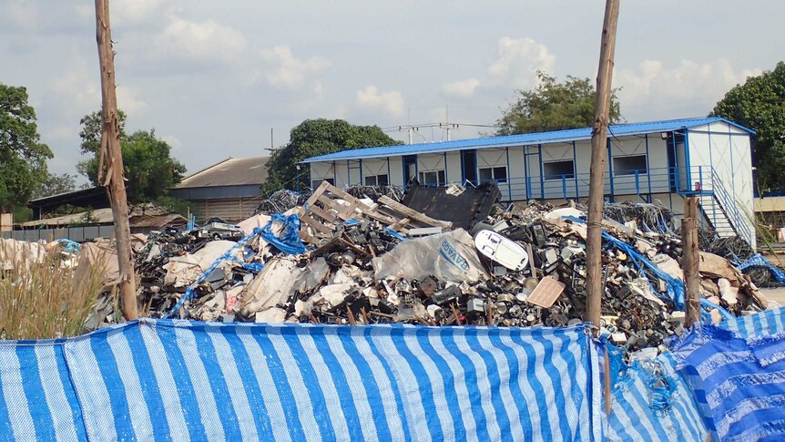 Huge piles of rubbish behind a plastic fence
